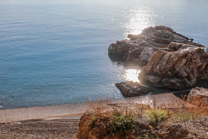 Calm sea and rocks below the villas