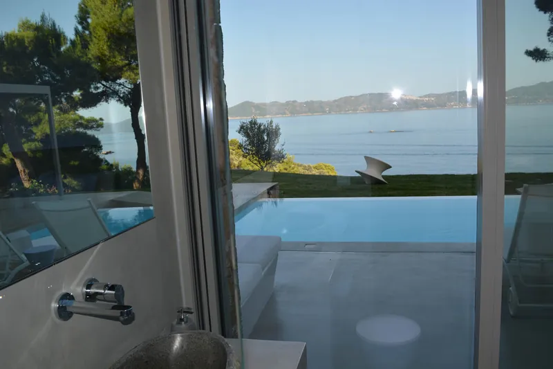 Glass doors open to the pool and the sea