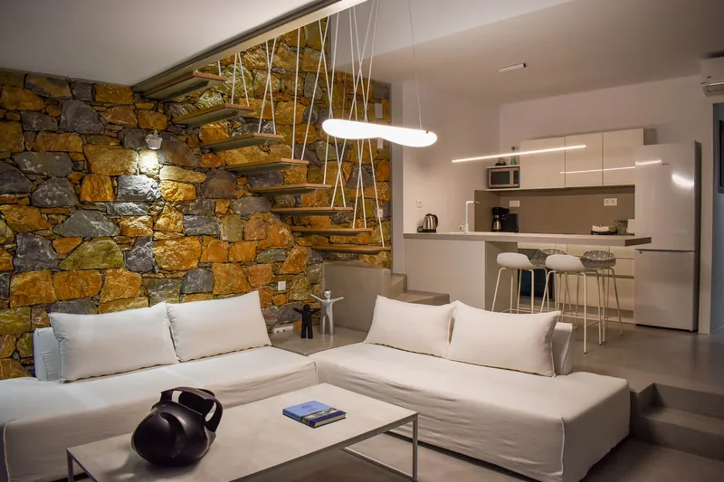 The living room with its stone wall and the kitchen