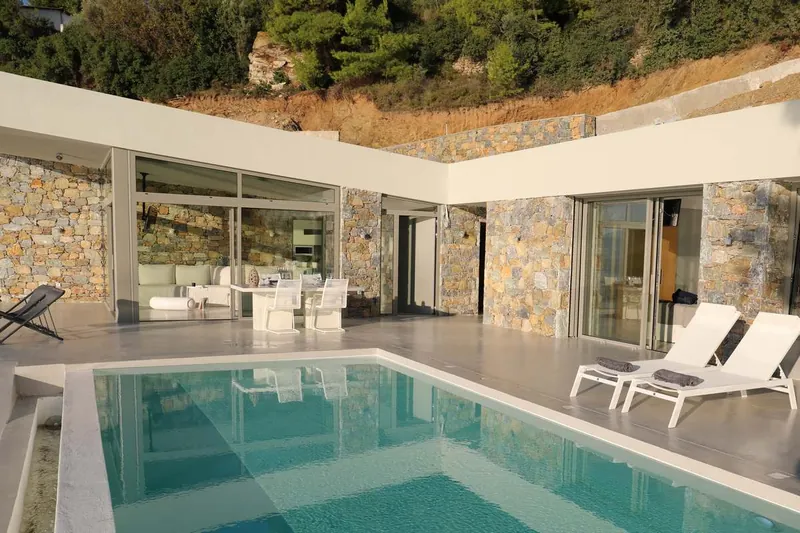 The pool and the villa’s glass front and stone walls