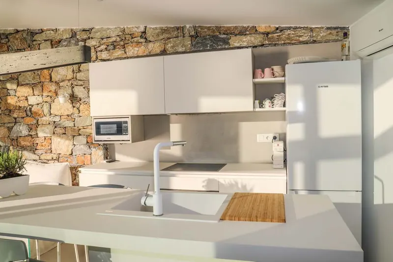 The white kitchen against the stone wall