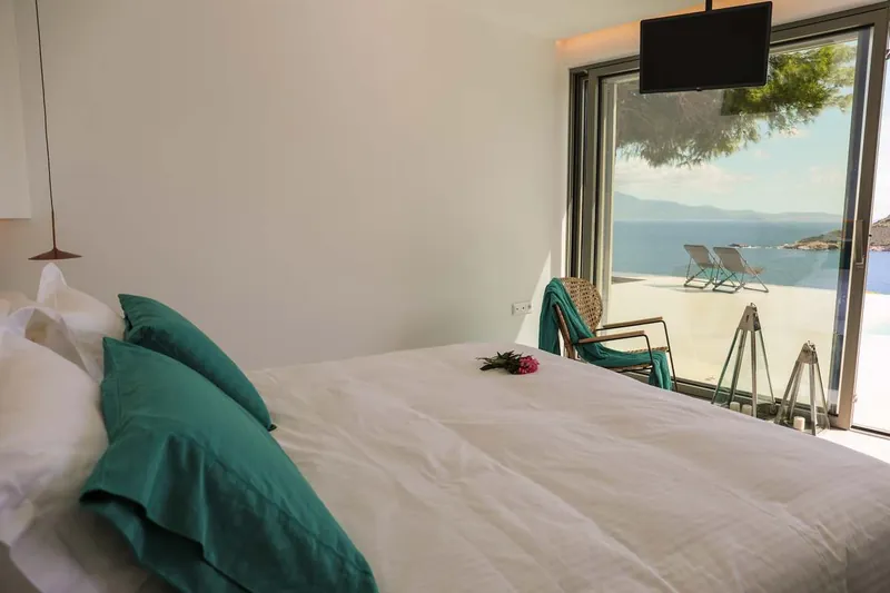 The bed facing the glass door to the sea